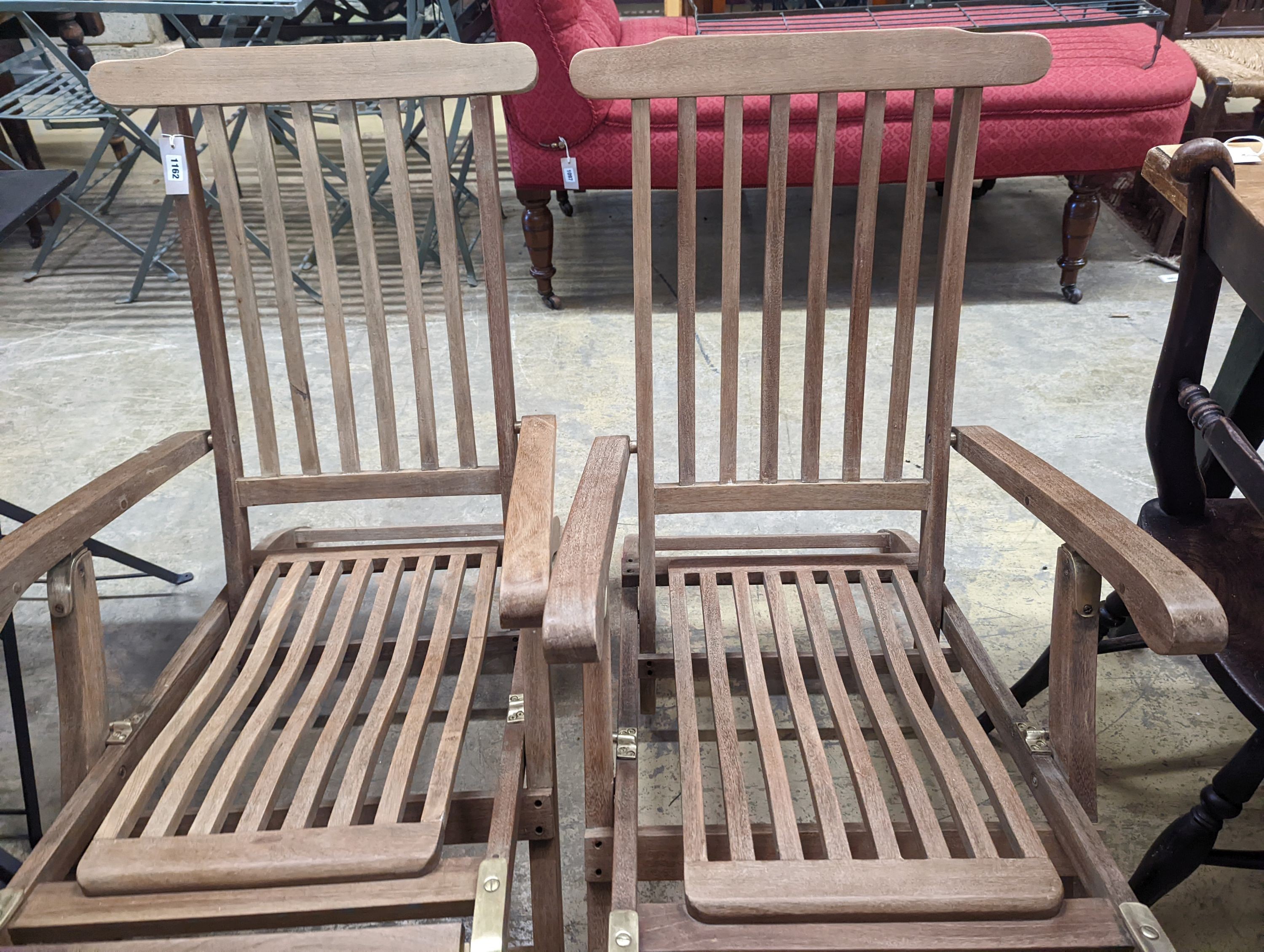 A pair of brass mounted teak garden steamer chairs, length 140cm, depth 58cm